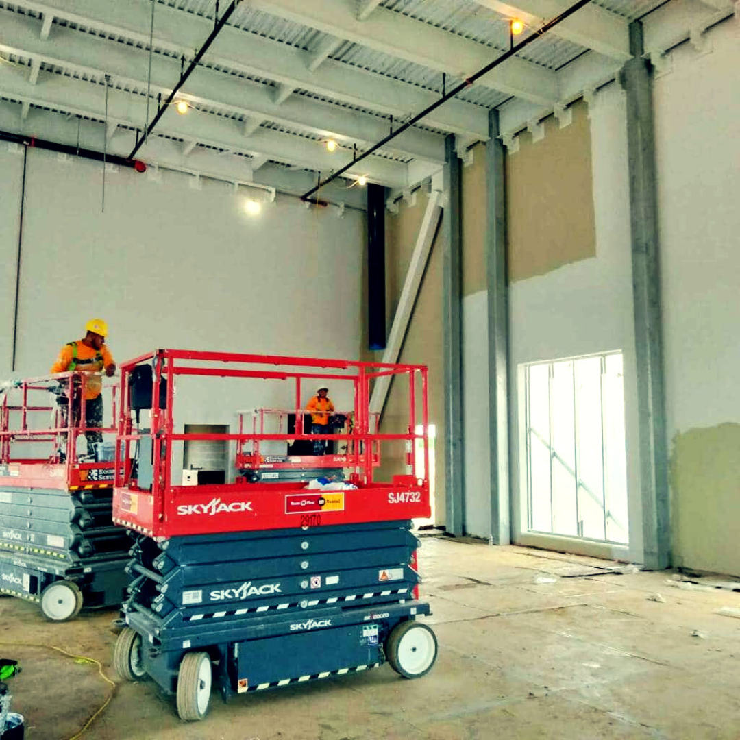 AGL painters on lifts inside a warehouse.